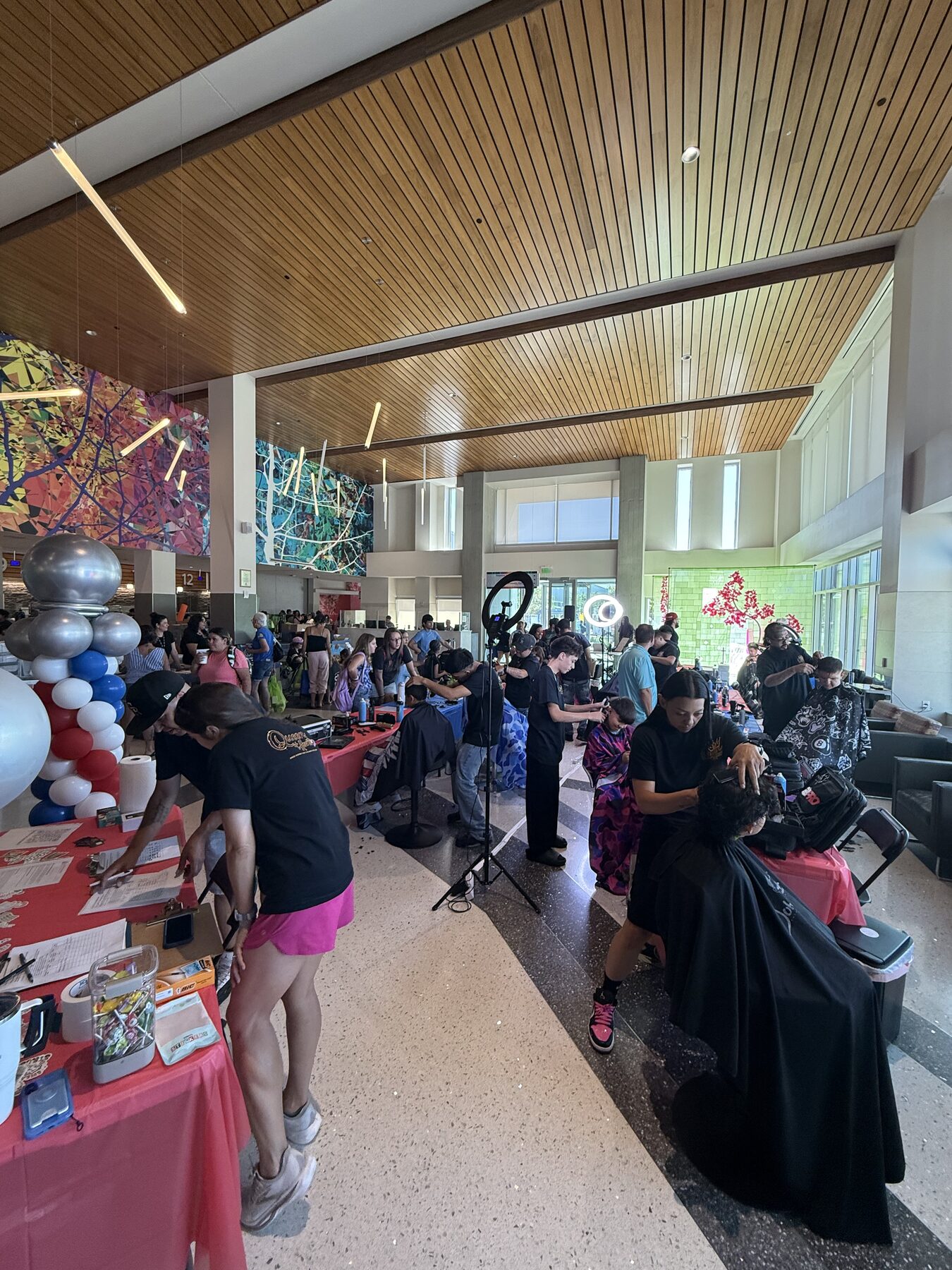 Volunteer stylists providing haircuts at busy event stations